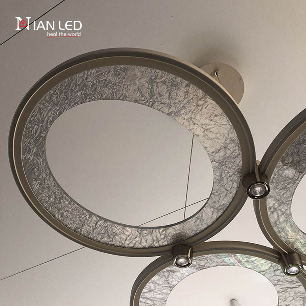Upward view of brushed champagne gold aluminum rings with textured glass panel and integrated aluminum downlight junction
