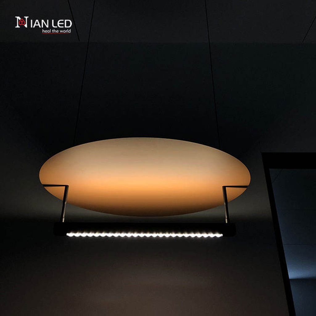 Warm halo lighting effect from linear aluminum LED bar reflecting off a bronze aluminum disc in a dark room