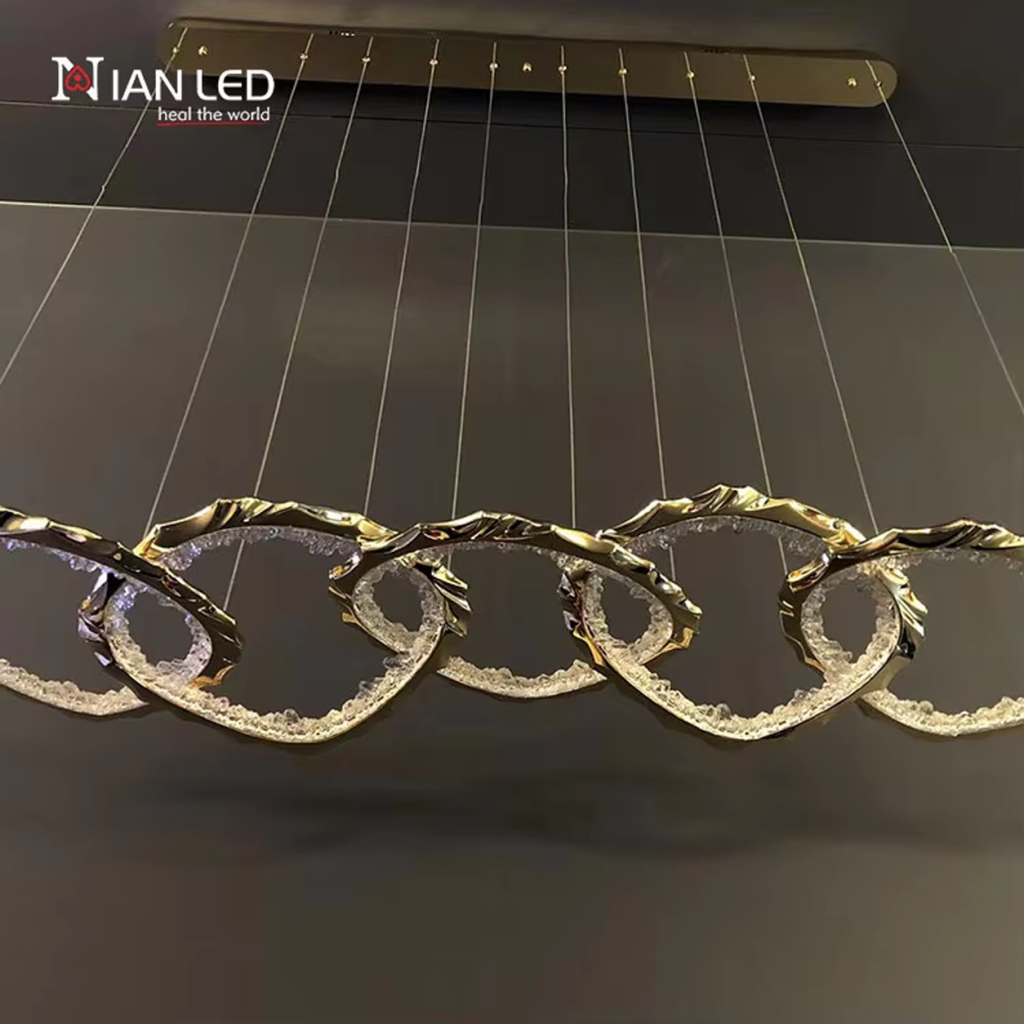 Linear view of gold wave chain pendant light showing multi-cable ceiling canopy suspension system
