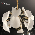 Modern blooming petal LED chandelier suspended in a contemporary luxury living room with beige sofas and wooden paneling