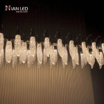 Detailed close-up of glowing glass-like optical acrylic feather shade with ice texture on polished zinc alloy mount