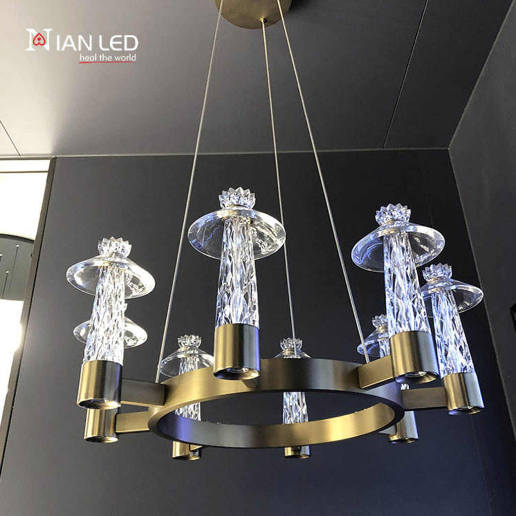 Detailed close-up of glowing diamond-cut faceted crystal pillar with saucer shade on brushed bronze stainless steel ring