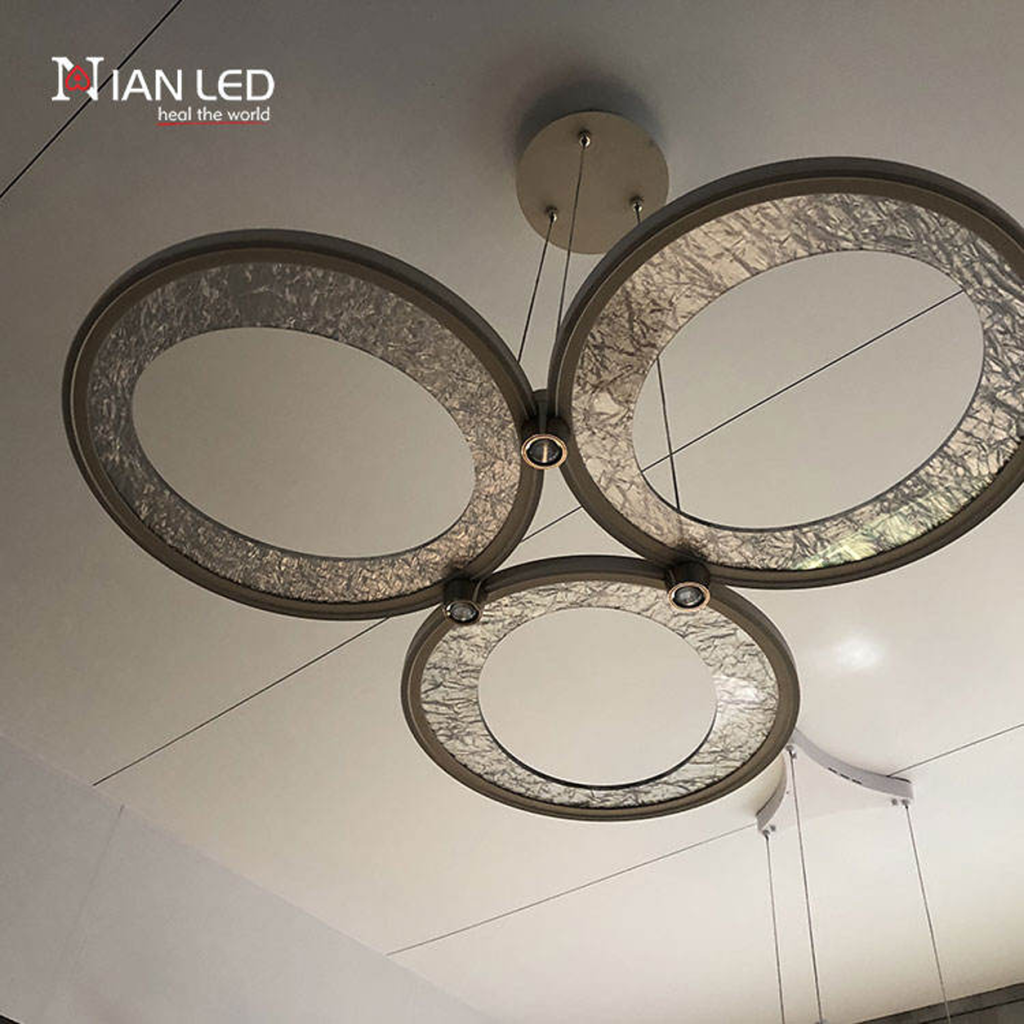 Upward view of brushed champagne gold aluminum rings with textured glass panel and integrated aluminum downlight junction