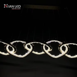 Linear view of gold wave chain pendant light showing multi-cable ceiling canopy suspension system