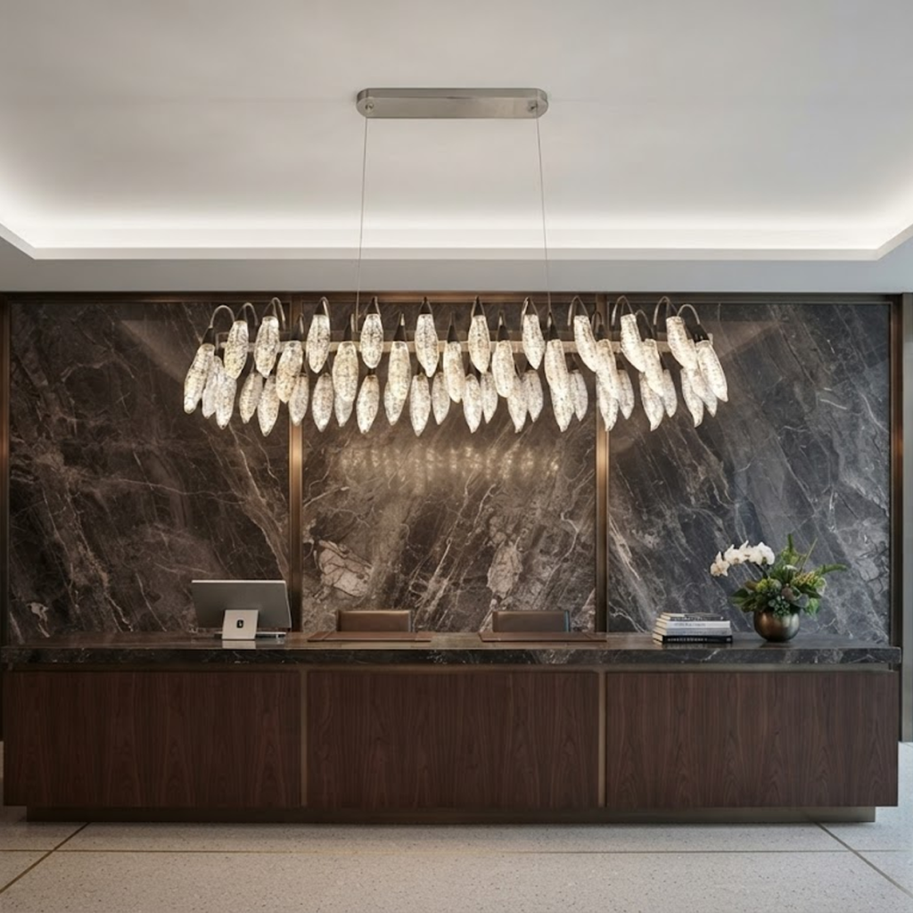 Large crystal-texture feather linear LED chandelier hanging above a luxury marble hotel reception desk in a contemporary lobby