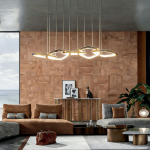 Modern organic vine interlocking ring linear LED chandelier hanging over a luxury living room sofa with gold mirror finish